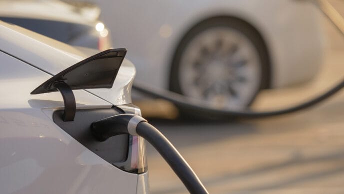 Electric cars charging at charging station outdoors at sunset. | Meridian Source