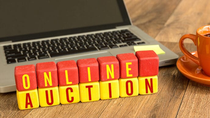 Online Auction written on a wooden cube in a office desk | Meridian Source