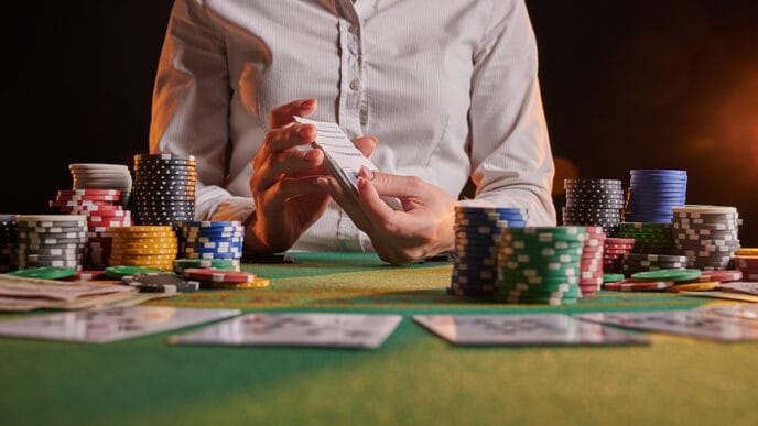 The dealer in the casino deals cards to the phonies with chips | Meridian Source