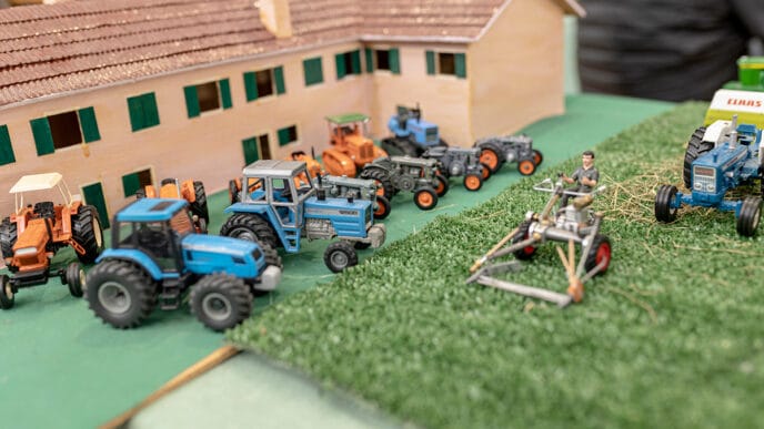 Miniature farm with tractors and farmer figurine on display at a | Meridian Source