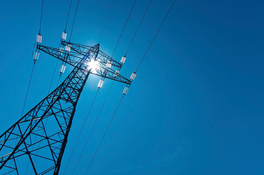 electricity pylon with sun and sky | Meridian Source