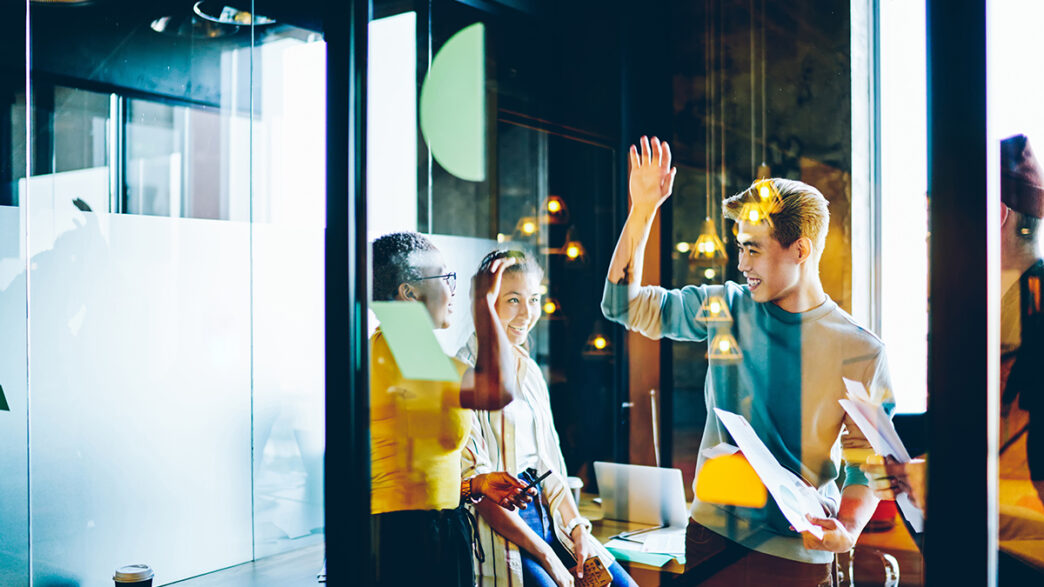 Happy young male and female employees accomplished project plann | Meridian Source