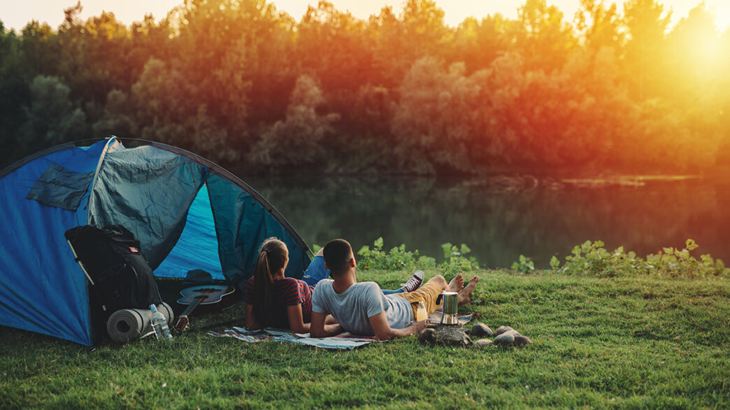 young couple relaxing by the river camping outdoor | Meridian Source
