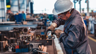 Skilled industrial worker grinding metal part | Meridian Source