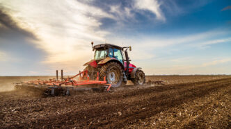 Tractor cultivating field at spring | Meridian Source