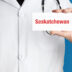 Saskatchewan Doctor in smock holds up business card The term S | Meridian Source