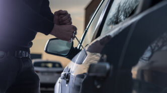 Auto thief in black balaclava trying to break into car | Meridian Source
