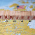 Wooden blocks spelling TARIFFS with a small US flag on top placed on a map highlighting Canada symbolizing trade policies and economic relations | Meridian Source