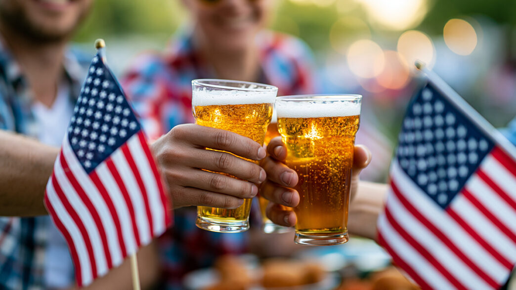 Close-up of friends celebrating Fourth of July with beers and Am | Meridian Source