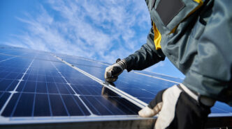 Male worker repairing photovoltaic solar panel | Meridian Source