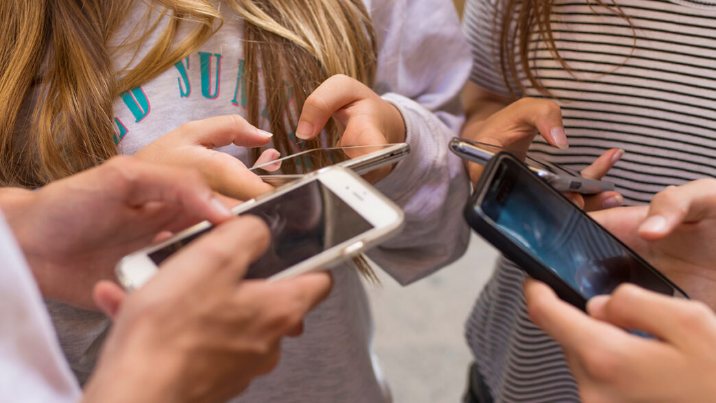 group of young people with mobile phones on the street | Meridian Source